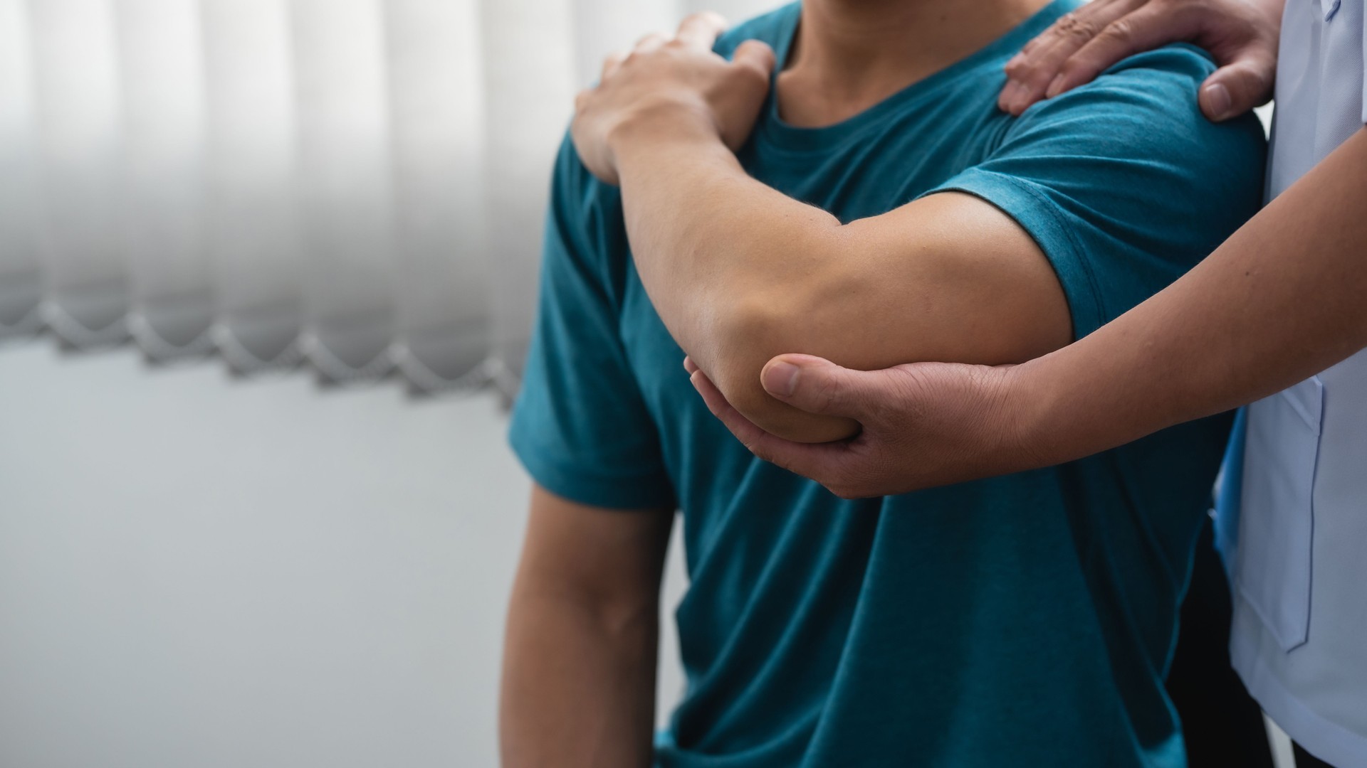 Physiotherapeut, der den Patienten bei der Armrehabilitation unterstützt. Gesundheits- und Physiotherapiekonzept